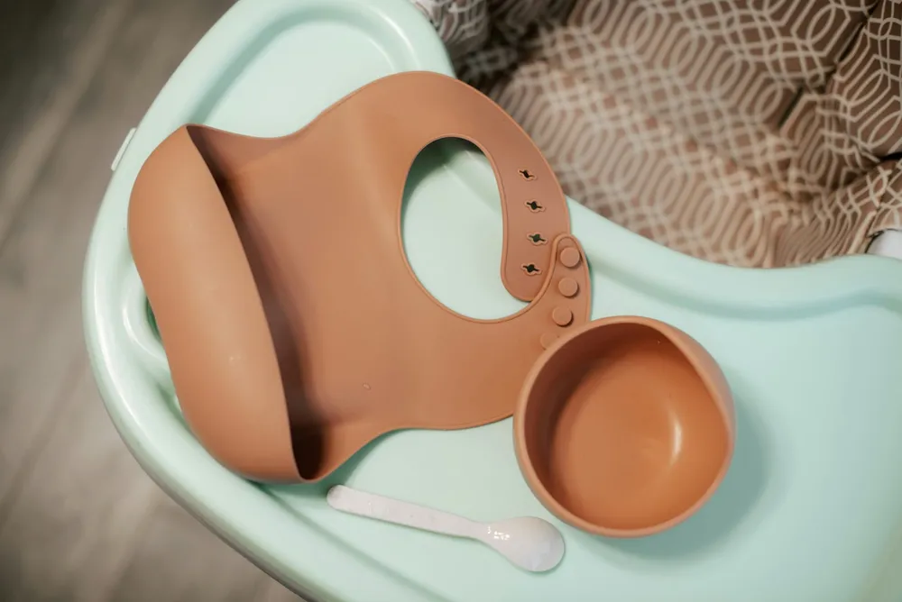 Miseczka z naturalnym warzywnym puree dla niemowlaka obok solniczki i cukiernicy przekreślonych symbolem zakazu — posiłek bez dodatku soli i cukru