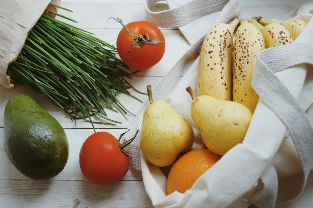 Talerz ze świeżymi, dostosowanymi do wieku produktami dla niemowlaka obok odłożonych na bok produktów niezalecanych — bezpieczne wybory podczas rozszerzania diety